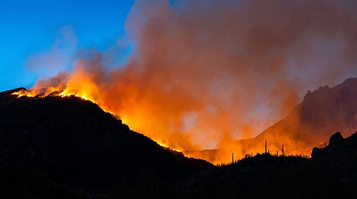 A fire burns along the ridge of mountain.